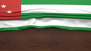 Abkhazia National Flag, Flag folded in half and placed on wood desk