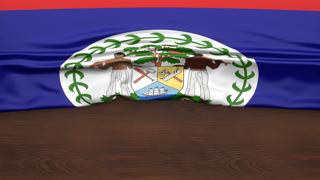 Belize National Flag, Flag folded in half and placed on wood desk