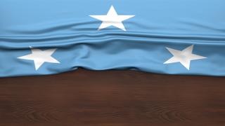 Federated-States-of-Micronesia National Flag, Flag folded in half and placed on wood desk