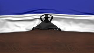 Lesotho National Flag, Flag folded in half and placed on wood desk