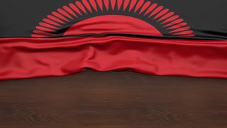 Malawi National Flag, Flag folded in half and placed on wood desk