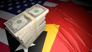 East-Timor National Flag, American dollars and flag placed on top of the American flag