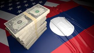 Laos National Flag, American dollars and flag placed on top of the American flag