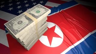 North-Korea National Flag, American dollars and flag placed on top of the American flag