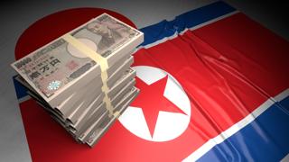 North-Korea National Flag, Japanese yen and national flag placed on top of the Japanese flag