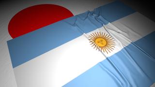 Argentina National Flag, The national flag placed on top of the Japanese flag on a desk in a dark space