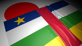 Central-African-Republic National Flag, The national flag placed on top of the Japanese flag on a desk in a dark space