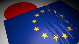 ヨーロッパ連合(EU)国旗, 暗い空間の中の机の上の日本の国旗の上に置かれた国旗