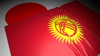 Kyrgyzstan National Flag, The national flag placed on top of the Japanese flag on a desk in a dark space