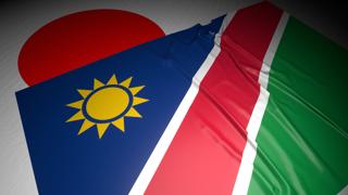 Namibia National Flag, The national flag placed on top of the Japanese flag on a desk in a dark space