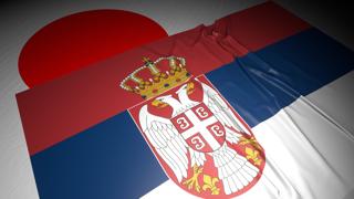 Serbia National Flag, The national flag placed on top of the Japanese flag on a desk in a dark space