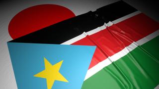 South-Sudan National Flag, The national flag placed on top of the Japanese flag on a desk in a dark space