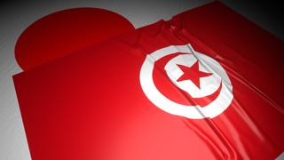 Tunisia National Flag, The national flag placed on top of the Japanese flag on a desk in a dark space