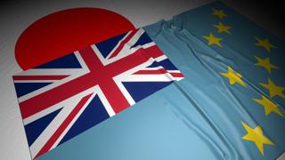 Tuvalu National Flag, The national flag placed on top of the Japanese flag on a desk in a dark space