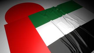 United-Arab-Emirates National Flag, The national flag placed on top of the Japanese flag on a desk in a dark space