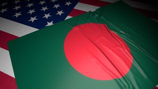 Bangladesh National Flag, A flag placed on top of an American flag on a desk in a dark space