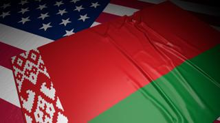 Belarus National Flag, A flag placed on top of an American flag on a desk in a dark space