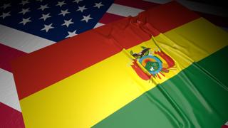 Bolivia National Flag, A flag placed on top of an American flag on a desk in a dark space