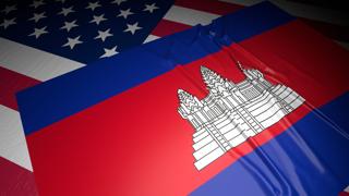 Cambodia National Flag, A flag placed on top of an American flag on a desk in a dark space