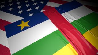 Central-African-Republic National Flag, A flag placed on top of an American flag on a desk in a dark space