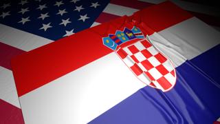 Croatia National Flag, A flag placed on top of an American flag on a desk in a dark space