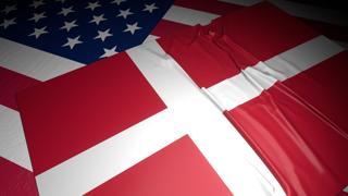 Denmark National Flag, A flag placed on top of an American flag on a desk in a dark space