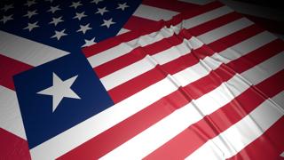 Liberia National Flag, A flag placed on top of an American flag on a desk in a dark space