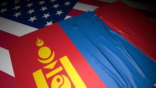 Mongolia National Flag, A flag placed on top of an American flag on a desk in a dark space