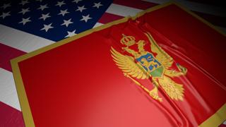 Montenegro National Flag, A flag placed on top of an American flag on a desk in a dark space