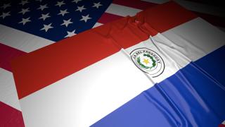 Paraguay National Flag, A flag placed on top of an American flag on a desk in a dark space