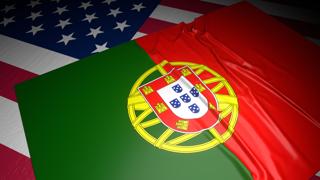 Portugal National Flag, A flag placed on top of an American flag on a desk in a dark space