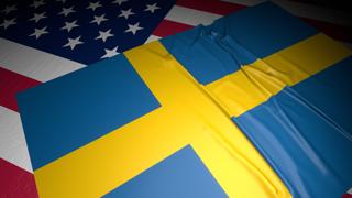 Sweden National Flag, A flag placed on top of an American flag on a desk in a dark space