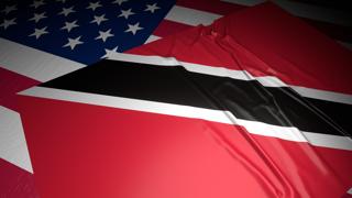 Trinidad-and-Tobago National Flag, A flag placed on top of an American flag on a desk in a dark space