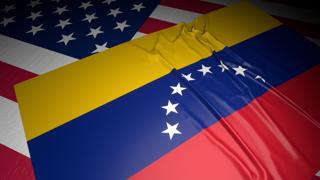 Venezuela National Flag, A flag placed on top of an American flag on a desk in a dark space