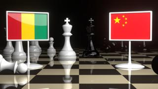 Guinea National Flag, The national flag on a chessboard with the Japanese flag in the background