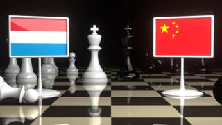 Luxembourg National Flag, The national flag on a chessboard with the Japanese flag in the background