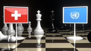 Switzerland National Flag, Flags placed on a chessboard with the UN flag in the background