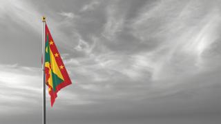 Grenada National Flag, The national flag and flagpole visible from afar against a black and white sky background