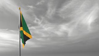 Jamaica National Flag, The national flag and flagpole visible from afar against a black and white sky background