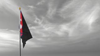 Nepal National Flag, The national flag and flagpole visible from afar against a black and white sky background