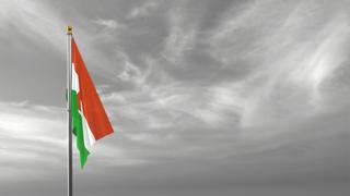 Niger National Flag, The national flag and flagpole visible from afar against a black and white sky background