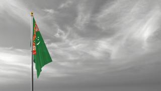 Turkmenistan National Flag, The national flag and flagpole visible from afar against a black and white sky background