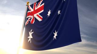 Australia National Flag, A fluttering flag and flagpole seen up close against a dark blue sky