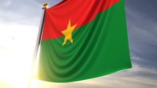 Burkina-Faso National Flag, A fluttering flag and flagpole seen up close against a dark blue sky