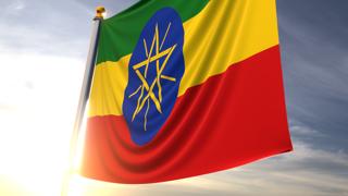 Ethiopia National Flag, A fluttering flag and flagpole seen up close against a dark blue sky