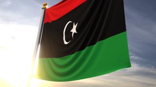 Libya National Flag, A fluttering flag and flagpole seen up close against a dark blue sky