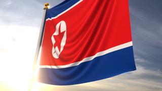 North-Korea National Flag, A fluttering flag and flagpole seen up close against a dark blue sky