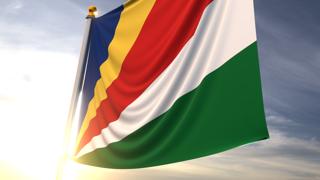 Seychelles National Flag, A fluttering flag and flagpole seen up close against a dark blue sky