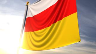 South-Ossetia National Flag, A fluttering flag and flagpole seen up close against a dark blue sky