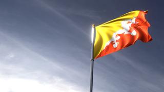 Butane National Flag, The national flag and flagpole looking up against a dark blue sky